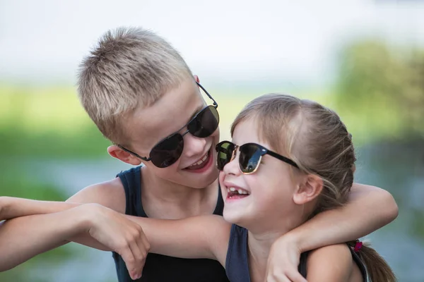 Dvě děti v černých slunečních brýlích se baví venku v součtu — Stock fotografie
