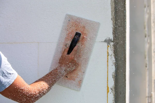 Mano de un trabajador con una herramienta para lijar y hacer suave y e — Foto de Stock