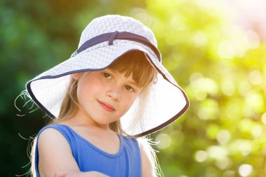 Büyük şapkalı mutlu gülümseyen küçük kızın yakın çekim portresi. Chi