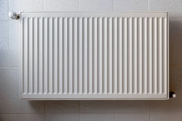 Radiador de aquecimento de metal branco montado em uma parede no interior do quarto . — Fotografia de Stock