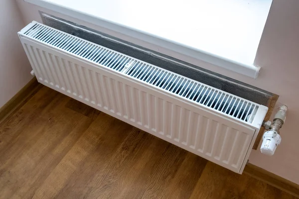 Radiador de aquecimento de metal branco montado em uma parede no interior do quarto . — Fotografia de Stock