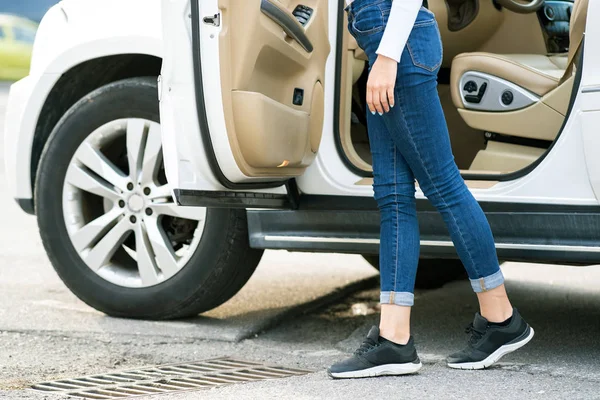 Женщина в джинсах и кроссовках стоит рядом с большой местности ок — стоковое фото