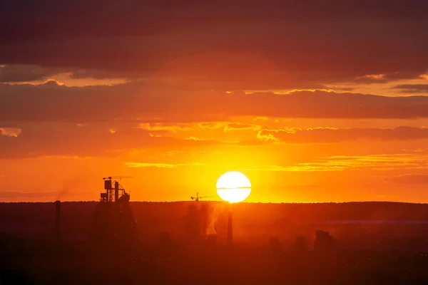 Żółty zachód słońca nad krajobrazem przemysłowym z kominów fabrycznych i — Zdjęcie stockowe