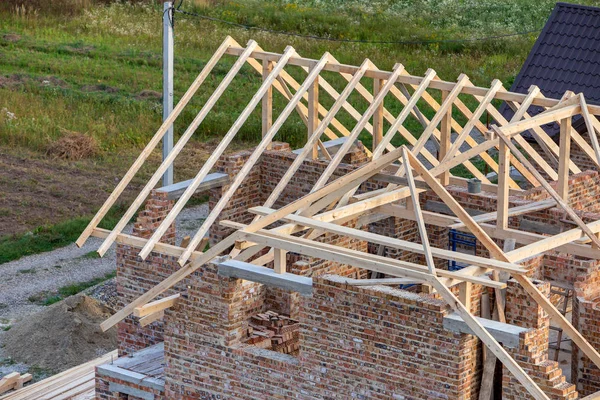 Незакінчений цегляний будинок з дерев'яною конструкцією даху під будівництво — стокове фото