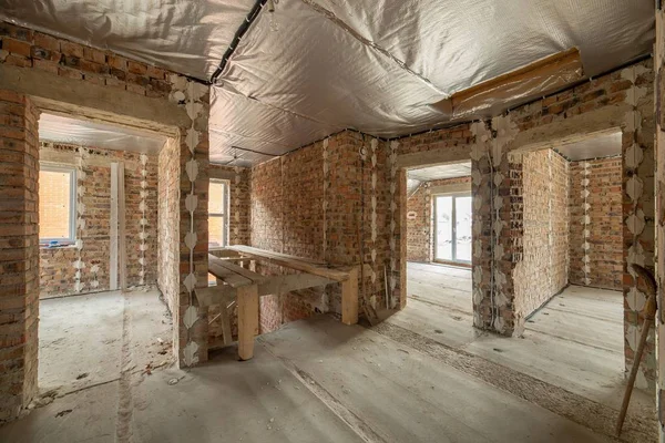 Innenraum eines unfertigen Backsteinhauses mit Betonboden und nackten — Stockfoto