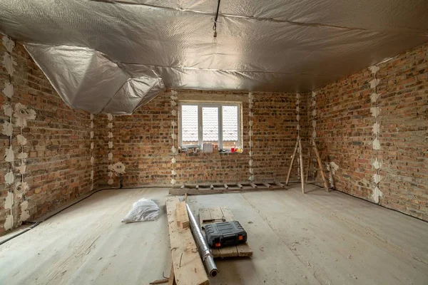 コンクリートの床と裸で未完成のレンガ造りの家のインテリア — ストック写真