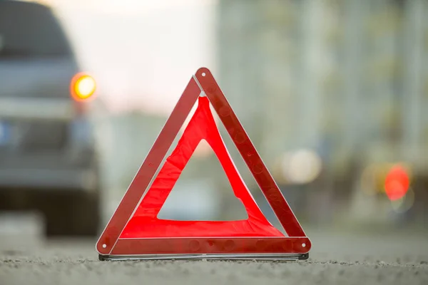 Triângulo de emergência vermelho parar sinal e carro quebrado em uma rua da cidade — Fotografia de Stock