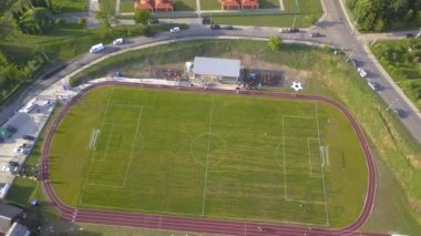 Kırsal bölgedeki yeşil çimlerle kaplı bir stadyumdaki futbol sahasının havadan görünüşü..