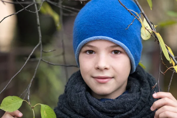 Mooi kind jongen dragen warme winter kleding houden boom tak — Stockfoto