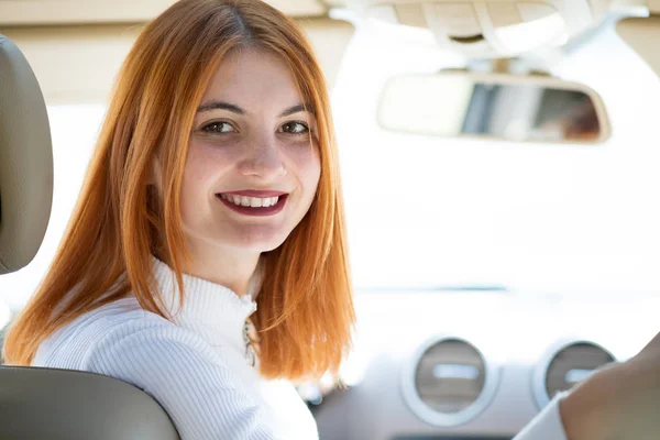 Joven pelirroja conductora conduciendo un coche sonriendo felizmente . — Foto de Stock