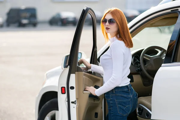 屋外の大きなすべての地形の車の近くに立っている容きれいな女性. — ストック写真