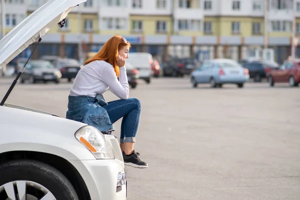 Молодая нервная женщина водитель рядом со сломанной машиной с выхлопным капюшоном вай — стоковое фото