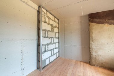 İnşaat halindeki bir odada tamamlanmamış tuğla duvar 