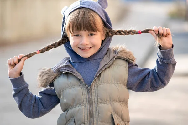 Portret van gelukkig kind meisje met haar vlechten in warme kleren in — Stockfoto