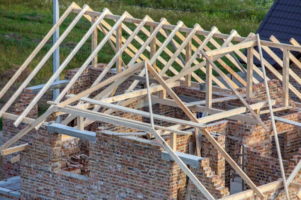 Onafgewerkte bakstenen huis met houten dak structuur onder constructie — Stockfoto