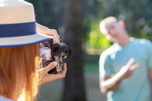 Young teenage couple taking pictures of one another outdoors in — Stock Photo, Image