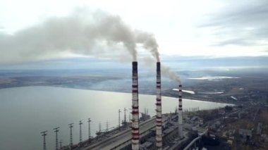 Kömür santralinden gelen gri dumanlı yüksek baca borularının havadan görüntüsü. Fosil yakıtla elektrik üretimi.
