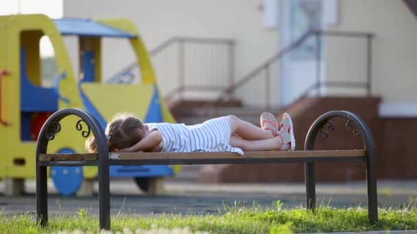 Nettes Mädchen Wartet Auf Der Bank Auf Dem Sommerspielplatz Hof — Stockvideo