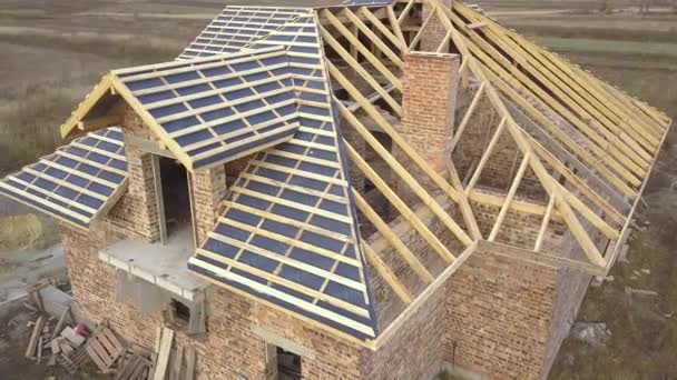 工事中の家の空中ビュー 屋根のための木製フレームと未完成のレンガ造りの建物 — ストック動画
