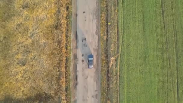 从空中俯瞰一辆汽车在有坑洞的糟糕道路上快速行驶的情景 — 图库视频影像