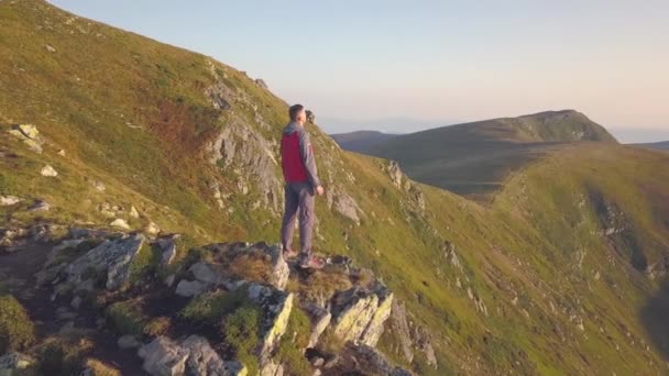 Der Wanderer Steht Auf Dem Gipfel Des Felsigen Berges Und — Stockvideo