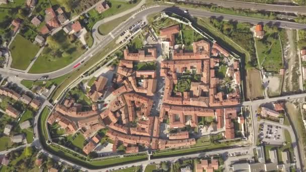 古い建物の赤いタイル張りの屋根を持つ北イタリアの小さな歴史的な町のベンゾーンの空中ビューのトップダウン — ストック動画