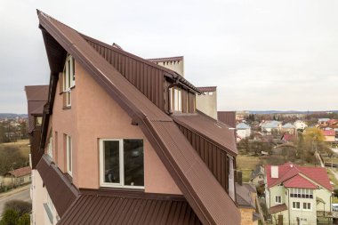 Birçok pencere ve metal levhaçatı ile yüksek apartman.