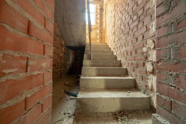 Tamamlanmamış tuğla evin içi çıplak duvarlarla dolu.