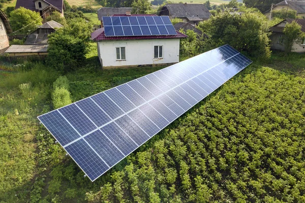 Widok z lotu ptaka na dom z niebieskimi panelami słonecznymi dla czystej energii. — Zdjęcie stockowe
