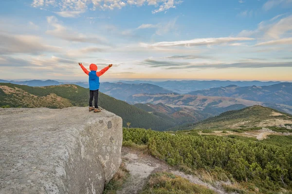 Menino jovem caminhante pé com as mãos levantadas em montanhas en — Fotografia de Stock