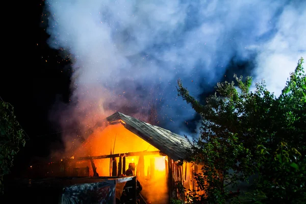 Wooden house or barn burning on fire at night. — Stock Photo, Image