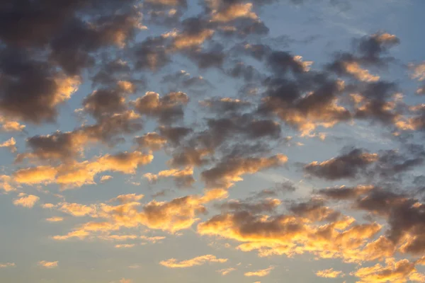 Закатное небо окутано оранжевыми пушистыми облаками. — стоковое фото