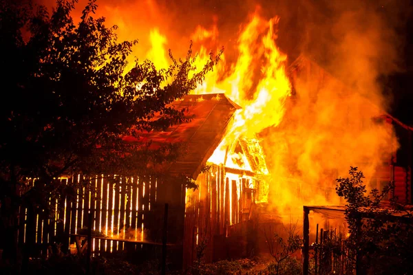 Holzhaus oder Scheune brennt in der Nacht. — Stockfoto