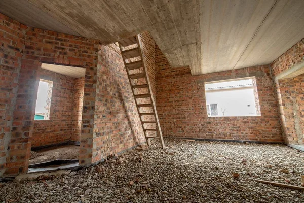 Interiör av ofullbordat tegelhus med betonggolv och bara — Stockfoto