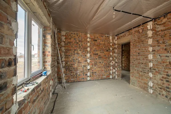 Interior da casa de tijolo inacabado com piso de concreto e nu — Fotografia de Stock