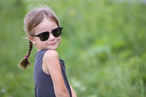 Retrato de niña bonita con trenzas en el pelo al aire libre en su —  Fotos de Stock