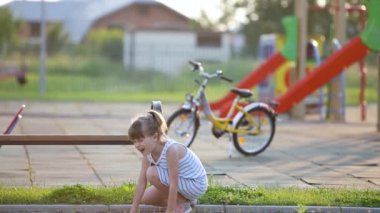 Küçük kız mutlu bir şekilde atlıyor ve acı verici bir şekilde ayağı takılıp bileğini burkuyor..