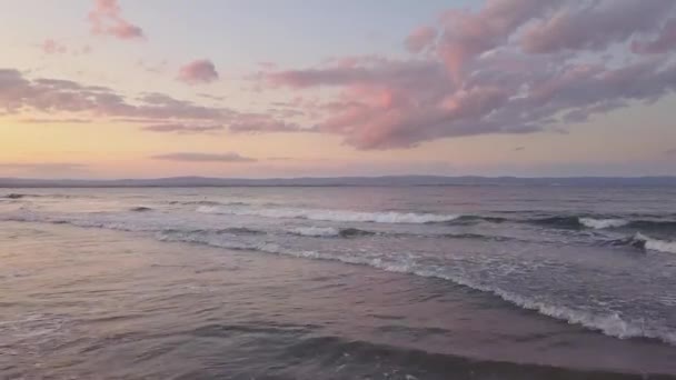 夕日の空の下で青い水の波と海の表面の空中写真 — ストック動画