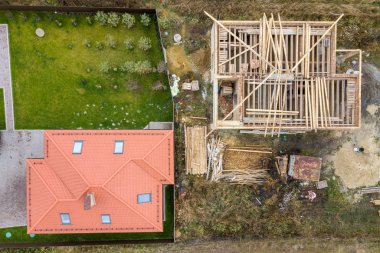 İki özel evin yukarıdan aşağı görüntüsü, biri yapım aşamasında.