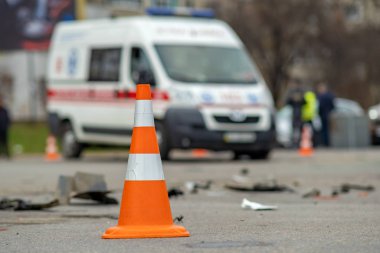 Araba kazasında bir caddeye yerleştirilmiş sarı plastik koni. Otur.