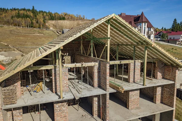 Marco de madera de techo nuevo en una casa grande de ladrillo en construcción — Foto de Stock