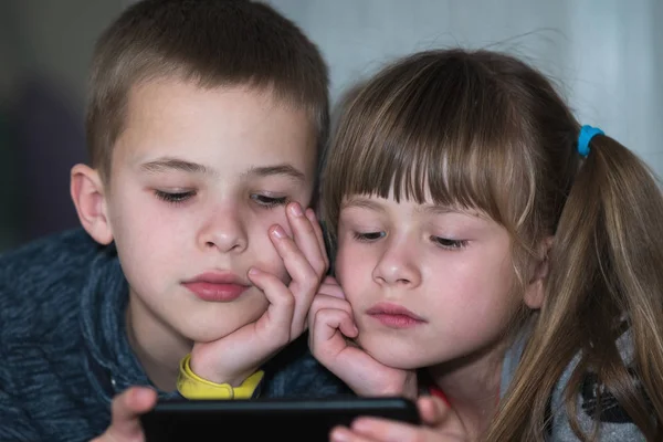 Dwójka dzieci brat i siostra oglądają filmy na smartfonie scr — Zdjęcie stockowe