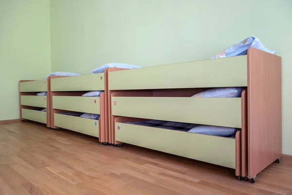 Πολλά μικρά κρεβάτια με καθαρά σεντόνια στον παιδικό σταθμό άδειο bedr — Φωτογραφία Αρχείου
