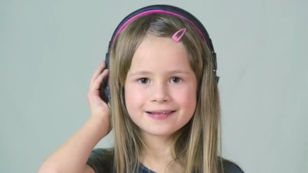 Bastante Chica Cild Sonriente Escuchando Música Grandes Auriculares Rosados — Vídeos de Stock