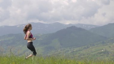 Genç kadın turist yaz dağlarında yürüyüş yaparken yoga hazımsızlığında ellerini kaldırıyor..