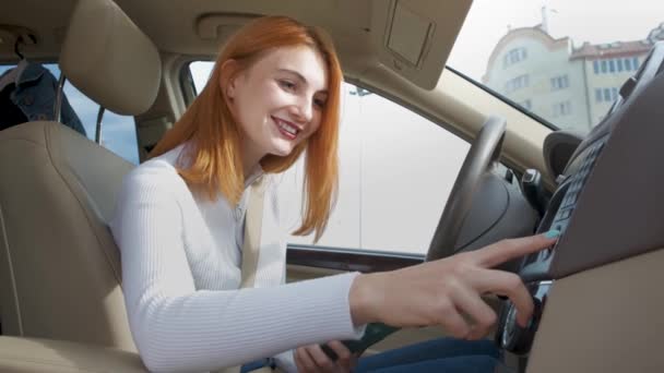 若い女性ドライバー車の中で音楽を聞いて車輪の後ろのラジオをチューニング — ストック動画