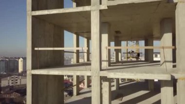 Bir şehirde inşaat halindeki yüksek apartmanın beton çerçevesinin havadan görünüşü.