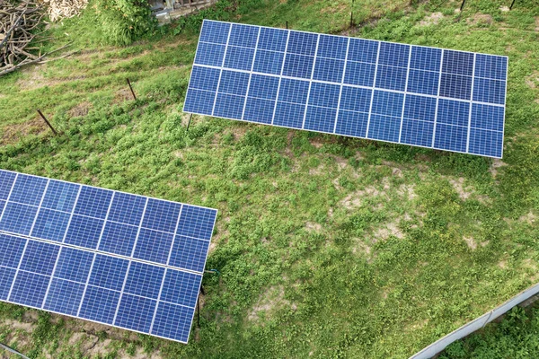 Aerial top down view of solar panels in green rural area.