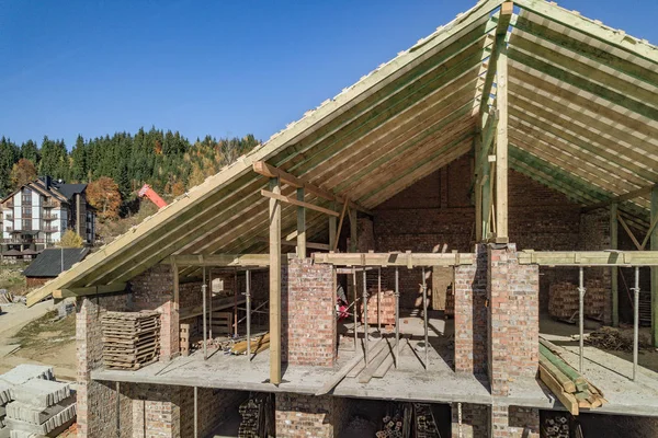 Marco de madera de techo nuevo en una casa grande de ladrillo en construcción — Foto de Stock