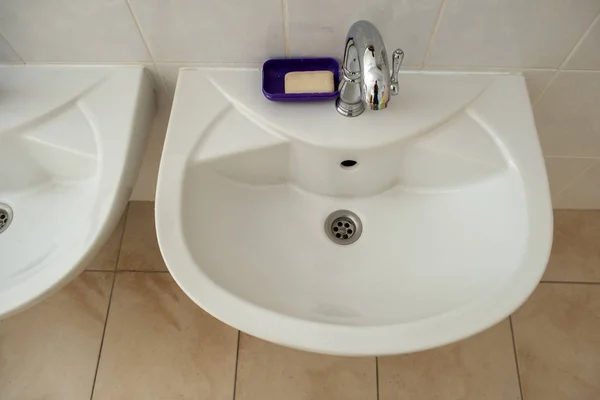 Lavabi in ceramica bianca con acqua lucida in acciaio inox ta — Foto Stock